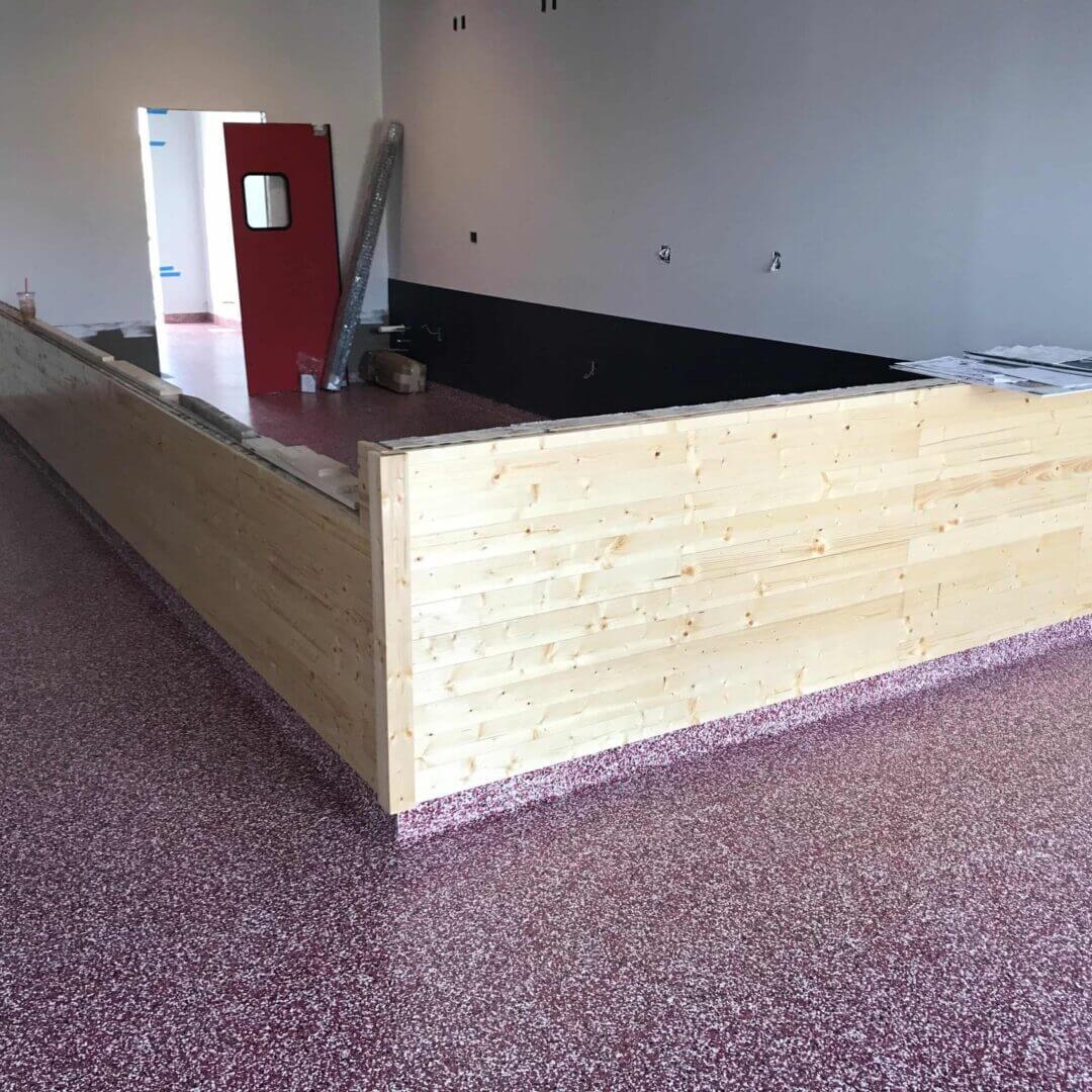 Wooden counter in a room under construction.