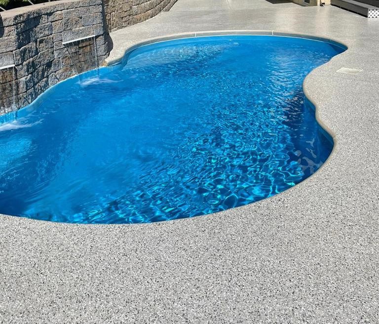 Backyard pool with stone waterfall feature.